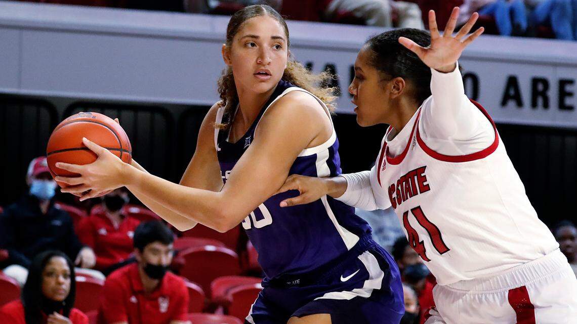 Kansas State’s Ayoka Lee (50) looks to pass the ball while being guarded by North Carolina State’s Camille Hobby (41) during the first half of an NCAA college basketball game Friday, Nov. 19, 2021, in Raleigh, N.C. (AP Photo/Karl B. DeBlaker)