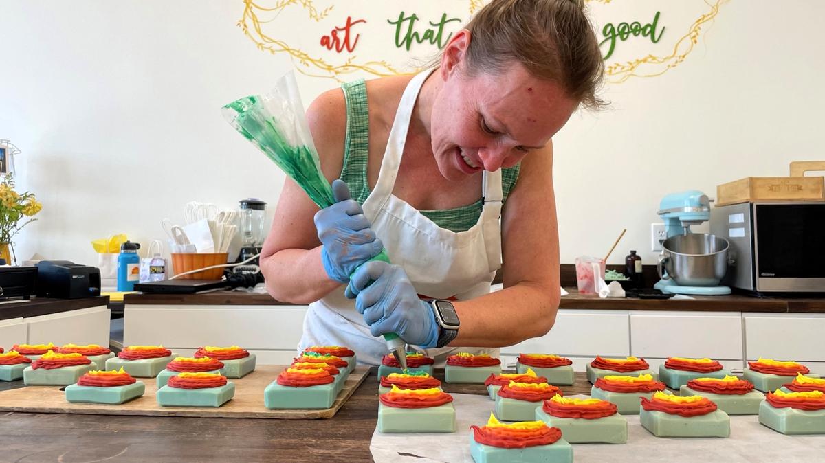 Brianna Cherner, owner of The Soap and Shine, pipes green soap onto four dozen bars decorated with rainbows for a child’s birthday party. Cherner made the move from corporate life to her own retail store in November 2024 at University Place in Chapel Hill.