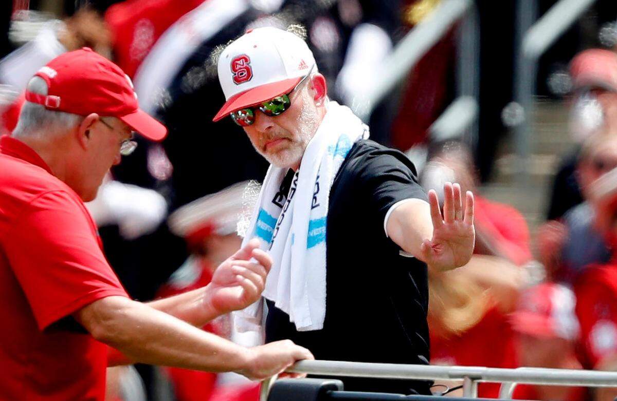 Robert M. Murphy Jr. (center in white hat) helps a crew move an injured football player in the first half of N.C. State’s game in 2018.