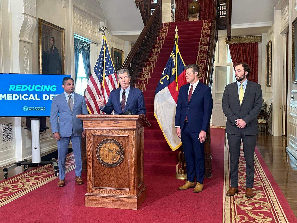 Gov. Roy Cooper and state Health and Human Services Secretary Kody Kinsley, second from right, unveiled their proposal in July to cut medical debt in North Carolina. Standing with them was John Broome of the American Cancer Society and Dave Almeida with the Leukemia & Lymphoma Society.
