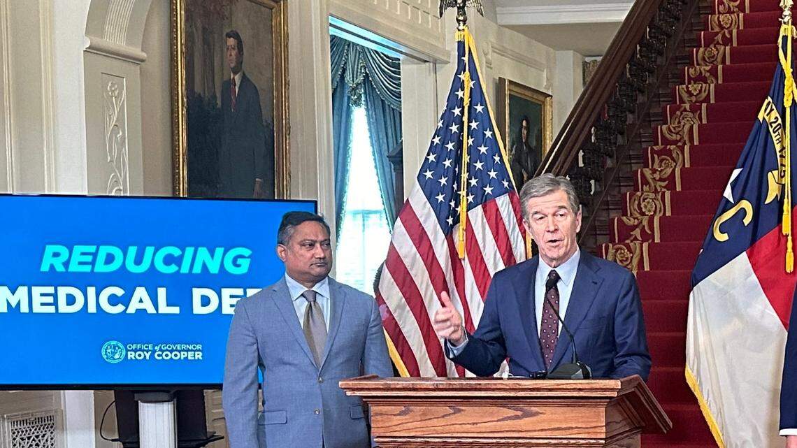 Gov. Roy Cooper unveils a new proposal to cut medical debt in North Carolina. Dave Almeida with the Leukemia & Lymphoma Society is at left.