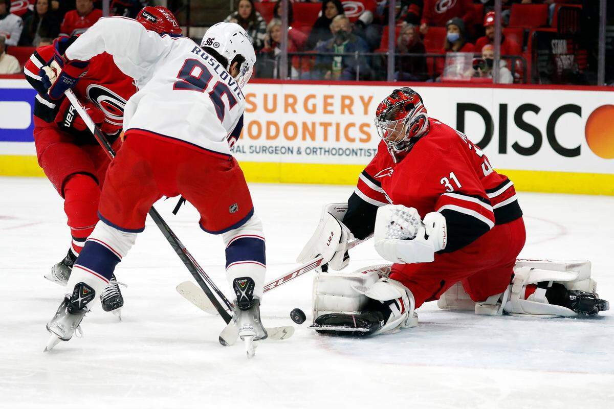 Carolina Hurricanes goaltender Frederik Andersen (31) turns away the shot of Columbus Blue Jackets’ Jack Roslovic (96) during the first period of an NHL hockey game in Raleigh, N.C., Thursday, Jan. 13, 2022. (AP Photo/Karl B DeBlaker)