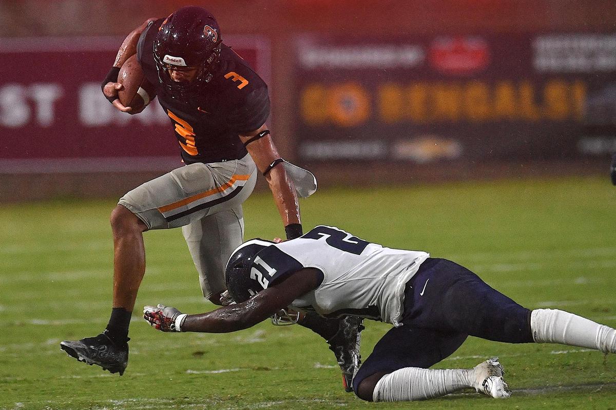 Fuquay-Varina’s Malcolm Ziglar (3) runs for yardage against Southeast Raleigh’s Zayvion Williams (21) in the first half. The Fuquay-Varina Bengals and the Southeast Raleigh Bulldogs played a conference football game in Fuquay-Varina, N.C. on September 22, 2023.