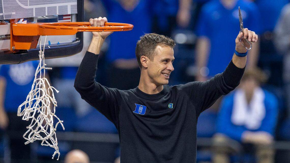 Duke coach Jon Scheyer celebrates by cutting down the net after leading the Blue Devils to an ACC Tournament Championship with a 59-49 victory over Virginia on Saturday, March 11, 2023 at the Greensboro Coliseum in Greensboro, N.C.