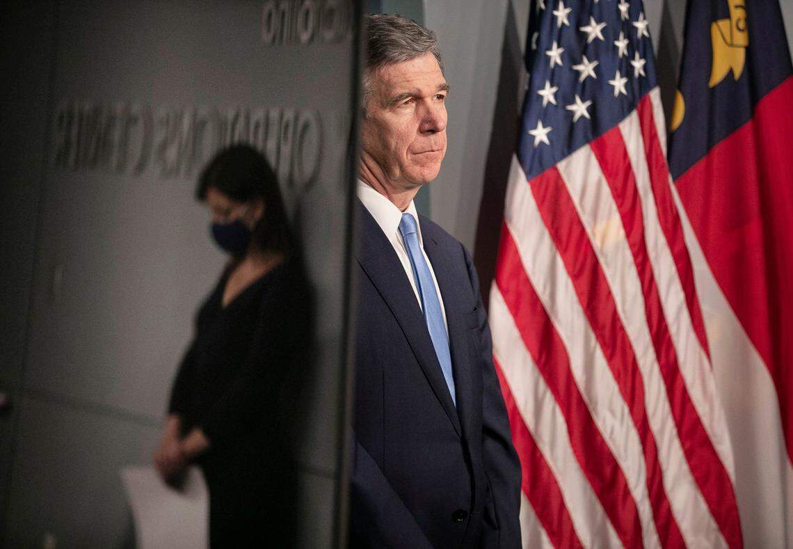 North Carolina Governor Roy Cooper and Dr. Mandy Cohen, Secretary of the North Carolina Department of Health and Human Services listen as Mike Sprayberry, Director of Emergency Management speaks during a press briefing on the COVID-19 virus at the Emergency Operations Center on Thursday, June 18, 2020 in Raleigh, N.C. Cohen is reflected in a television monitor positioned next to Governor Cooper.