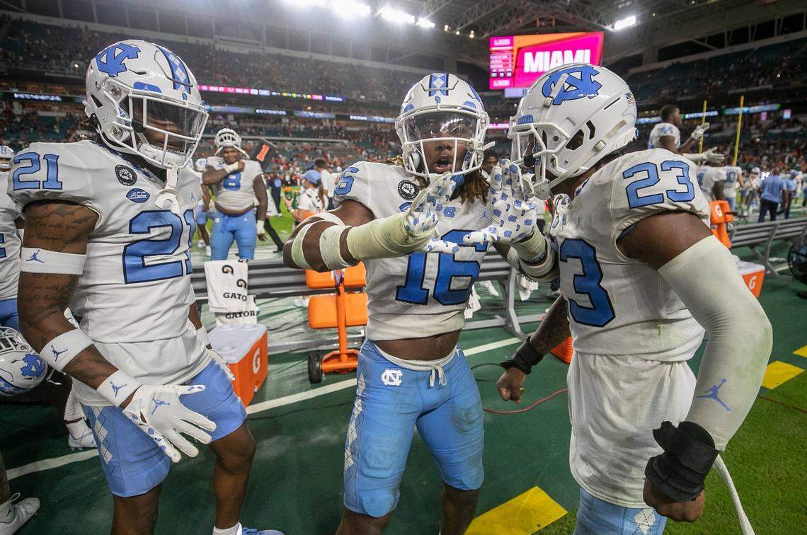North Carolina defensive back DeAndre Boykins (16) celebrates with teammates Dontavius Nash (21) and Power Echols (23) after Boykins’ interception of Miami quarterback Tyler Van Dyke with eight seconds to play to secure the Tar Heels’ 27-24 victory on Saturday, October 8, 2022 at Hard Rock Stadium in Miami Gardens, Florida.