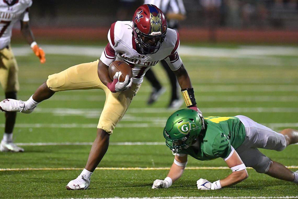 Mallard Creek running back Xavier Edmond (21) avoids the tackle from Cardinal Gibbons linebacker Skylar Alston (11) during the first half. The Mallard Creek Mavericks and the Cardinal Gibbons Crusaders met in a non-conference football game in Raleigh, N.C. September 19, 2025