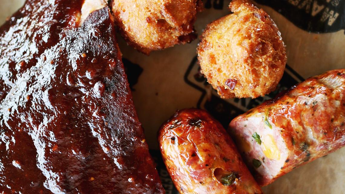 Maverick’s in Durham serves Memphis dry-rubbed ribs and smoked house-made jalapeño-cheddar sausage with collard greens with house beef, hush puppies and bourbon baked beans seasoned with ham hock.