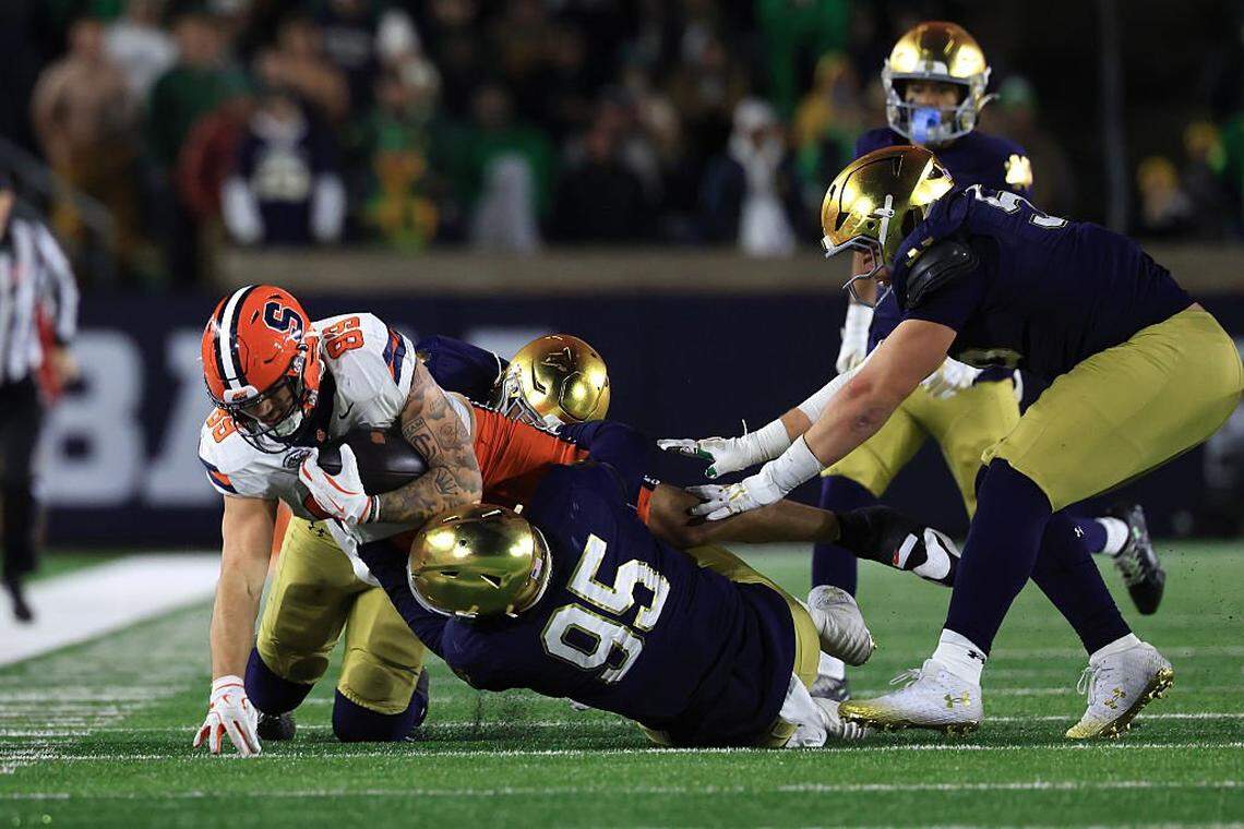 SOUTH BEND, INDIANA - NOVEMBER 22: Dan Villari #89 of the Syracuse Orange is tackled by Bryce Young #95 of the Notre Dame Fighting Irish during the second half at Notre Dame Stadium on November 22, 2025 in South Bend, Indiana. (Photo by Justin Casterline/Getty Images)