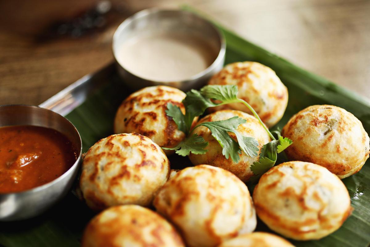 Kuzhi paniyaram are rice-flour dough balls flecked with chopped onion, chiles and coconut are pan-fried at Anjappar in Cary.