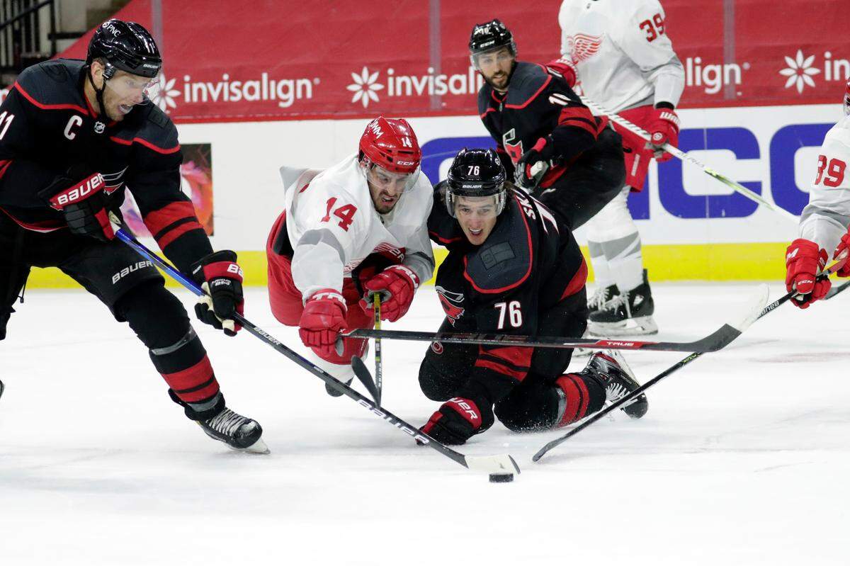 Carolina Hurricanes’ Jordan Staal (11) and Brady Skjei (76) battle Detroit Red Wings’ Robby Fabbri (14) for the puck during the first period of an NHL hockey game in Raleigh, N.C., Thursday, March 4, 2021. (AP Photo/Chris Seward)