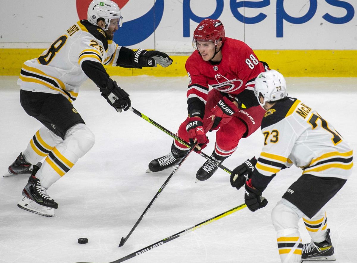 Carolina Hurricanes’ Martin Necas (88) works the puck between Boston’s Derek Forbort (28) and Charlie McAvoy (73) during the first period on Thursday, October 28, 2021 at PNC Arena in Raleigh, N.C.