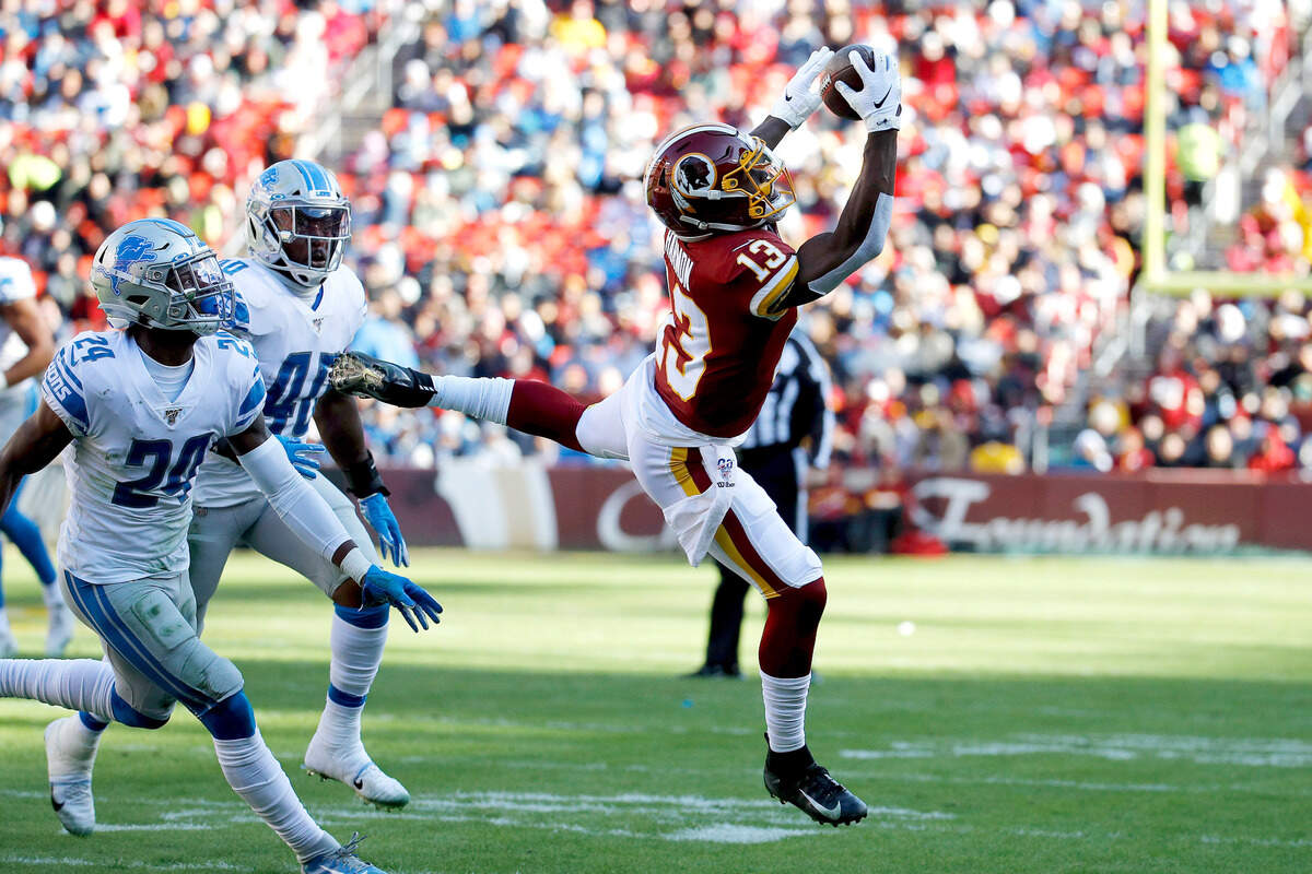 Washington Redskins wide receiver Kelvin Harmon (13) makes a catch as Detroit Lions cornerback Amani Oruwariye (24) and middle linebacker Jarrad Davis (40) defend during the first half of an NFL football game, Sunday, Nov. 24, 2019, in Landover, Md.