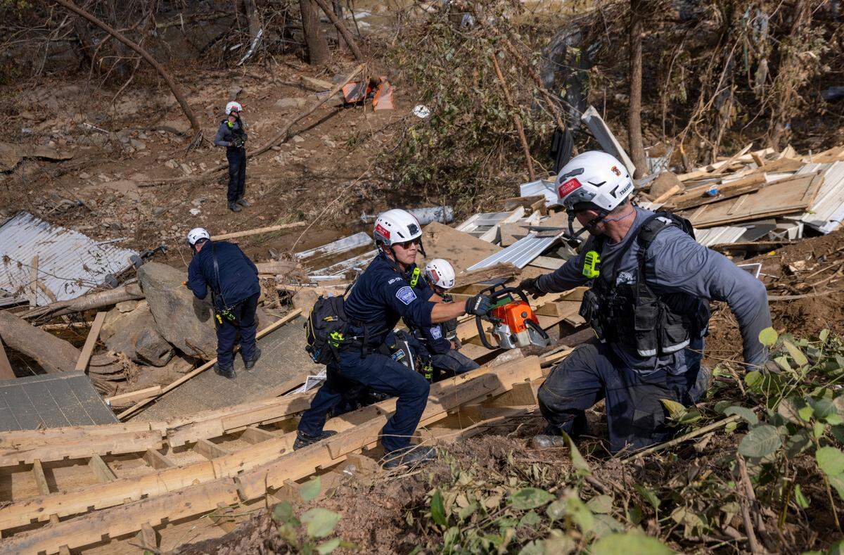 A FEMA search and rescue team from Maryland search for human remains in debris from a structure in Swannanoa on Sunday, Oct. 6, 2024 after Tropical Storm Helene flooded the Swannanoa River. North Carolina officials have confirmed 76 deaths from Tropical Storm Helene.