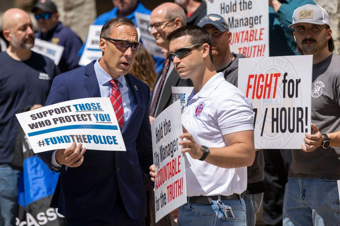 Rick Armstrong from Teamsters Local 391, left, and Andrew Davis, of the Raleigh Professional Firefighters Association, demonstrate for high wages for Raleigh police and firefighters on Tuesday, April 19, 2022 in Raleigh, N.C.