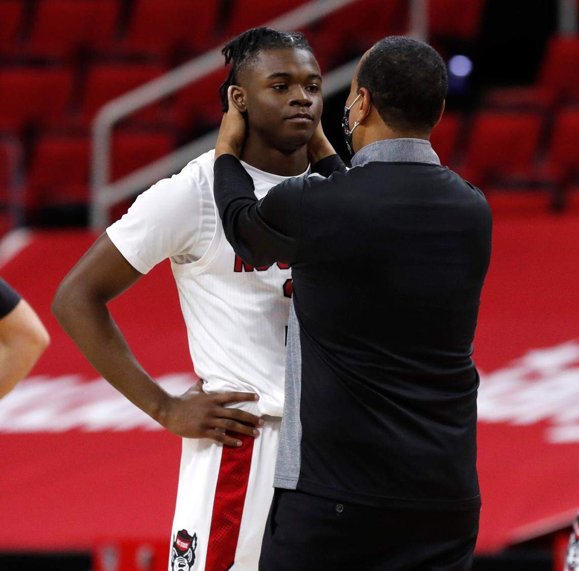 N.C. State head coach Kevin Keatts talks with Cam Hayes (3) during the second half of N.C. State’s 72-67 victory over Wake Forest at PNC Arena in Raleigh, N.C., Wednesday, January 27, 2021.
