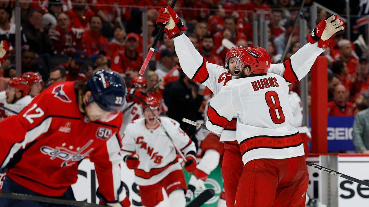 May 6, 2025; Washington, District of Columbia, USA; Carolina Hurricanes defenseman Jaccob Slavin (74) celebrates with teammates after scoring the game winning goal in overtime against the Washington Capitals in game one of the second round of the 2025 Stanley Cup Playoffs at Capital One Arena. 