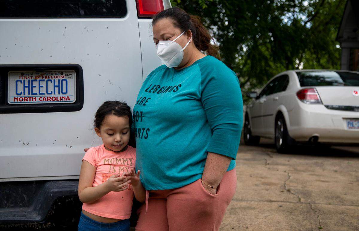 Lesly Zelaya, 47, and her daughter Bridget, 5, stand outside of their home in Raleigh next to the work van left behind by her husband Mauricio Friday May 1, 2020. He was arrested by immigration officials for being in the country illegally and has been in immigration detention since February.