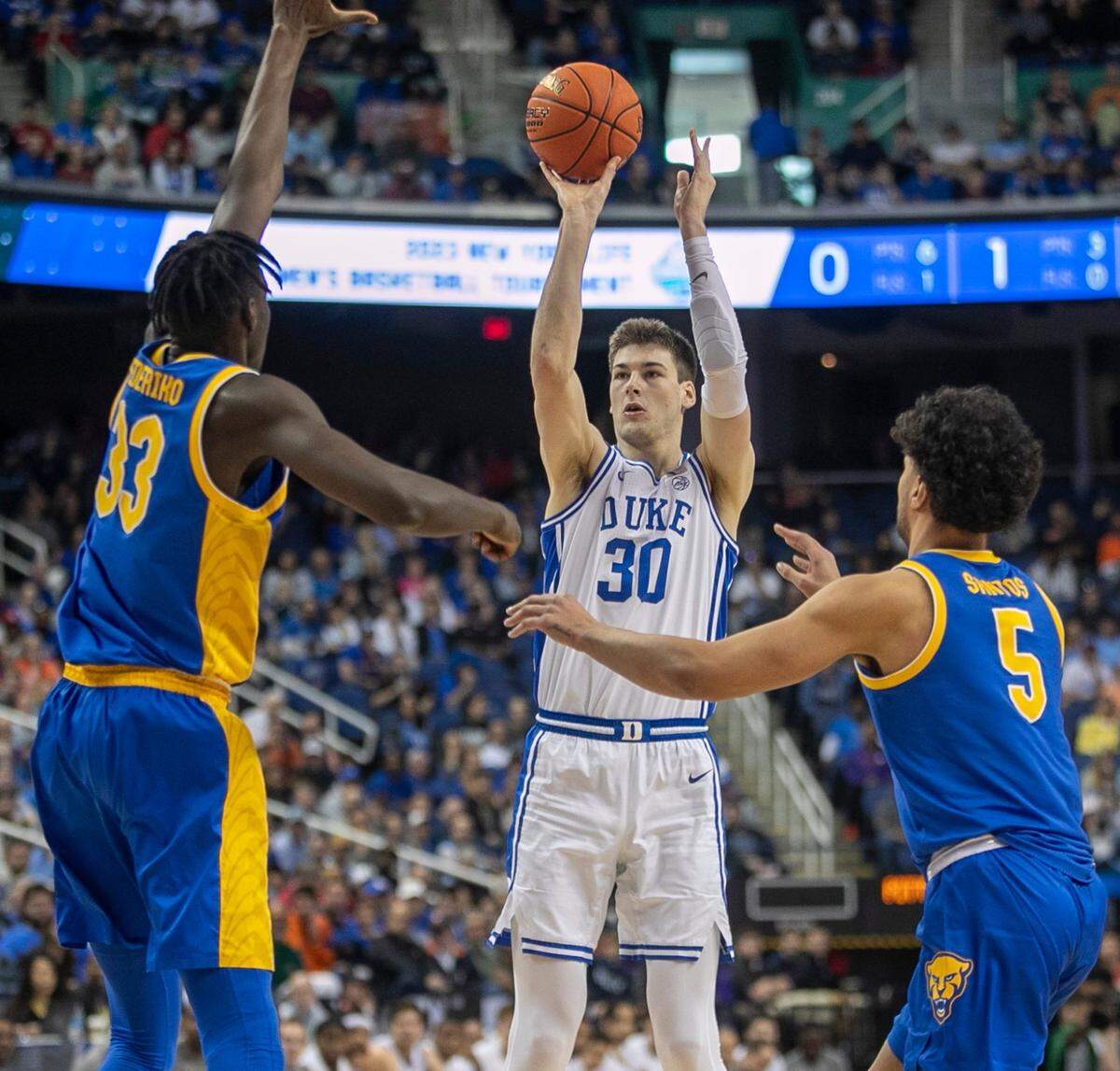 Duke’s Kyle Filipowski (30 sinks three point basket in the first half against Pittsburgh’s Federiko Federiko (33) and Nate Santos (5) to give the Blue Devils’ a 15 point lead during the third round of the ACC Tournament on Thursday, March 9, 2023 at the Greensboro Coliseum in Greensboro, N.C. 