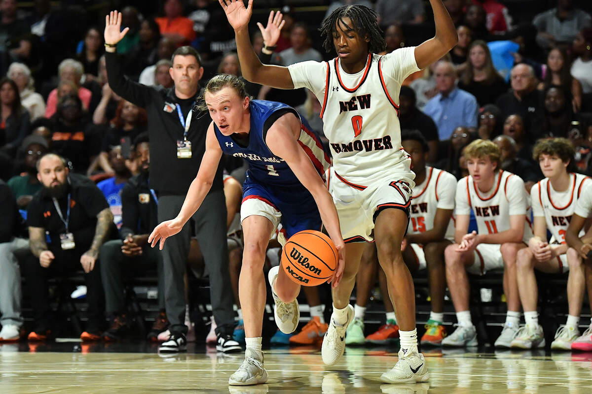 Sanderson’s Gordie Balas drives ahead of New Hanover’s Kellum Brown (0) during the first half. The Sanderson Spartans and the New Hanover Wildcats met in the NCHSAA 4A East Regional Final in Winston-Salem, N.C. on March 12, 2025.