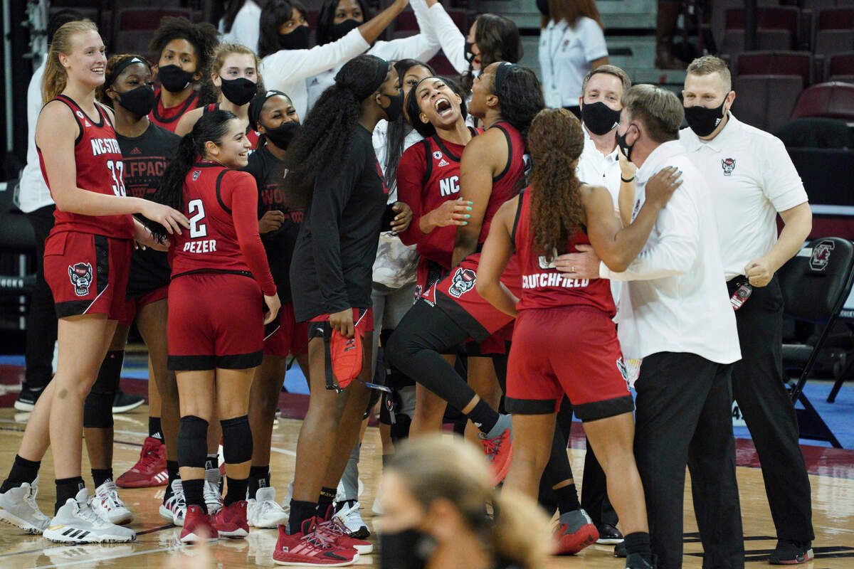 North Carolina State players celebrate with the coaching staff after their victory over South Carolina Thursday, Dec. 3, 2020, in Columbia, S.C.