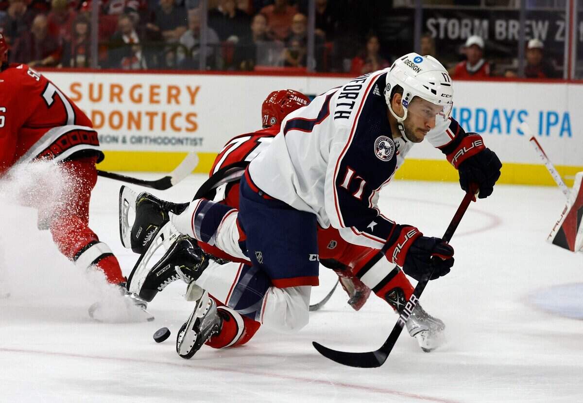 Carolina right wing Jesper Fast (71) stops Columbus right wing Justin Danforth (17) during the first period of the Carolina Hurricanes game against the Columbus Blue Jackets at PNC Arena in Raleigh, N.C., Wednesday, Oct. 12, 2022.