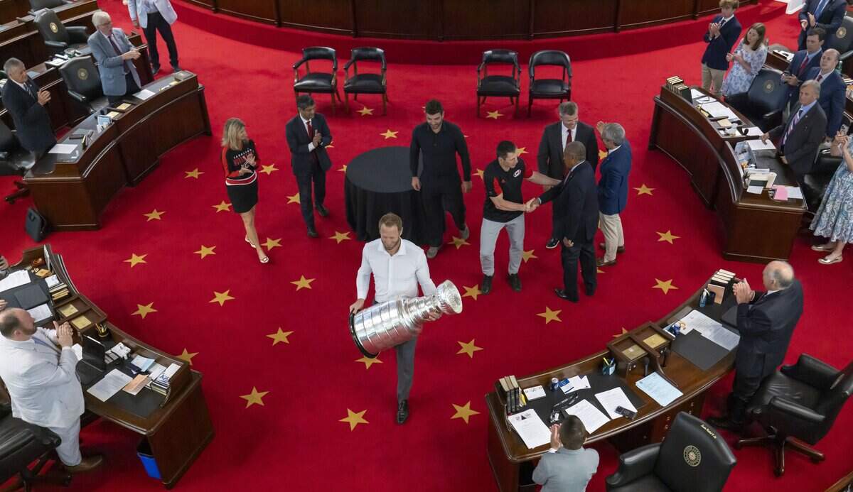 Carolina Hurricanes captain Jordan Staal leaves the Senate Chamber with the Stanley Cup, as head coach Rod Brind’Amour shakes hands with Senator Dan Blue, after the team was honored by lawmakers on Tuesday, June 23, 2026 at the General Assembly in Raleigh, NC.