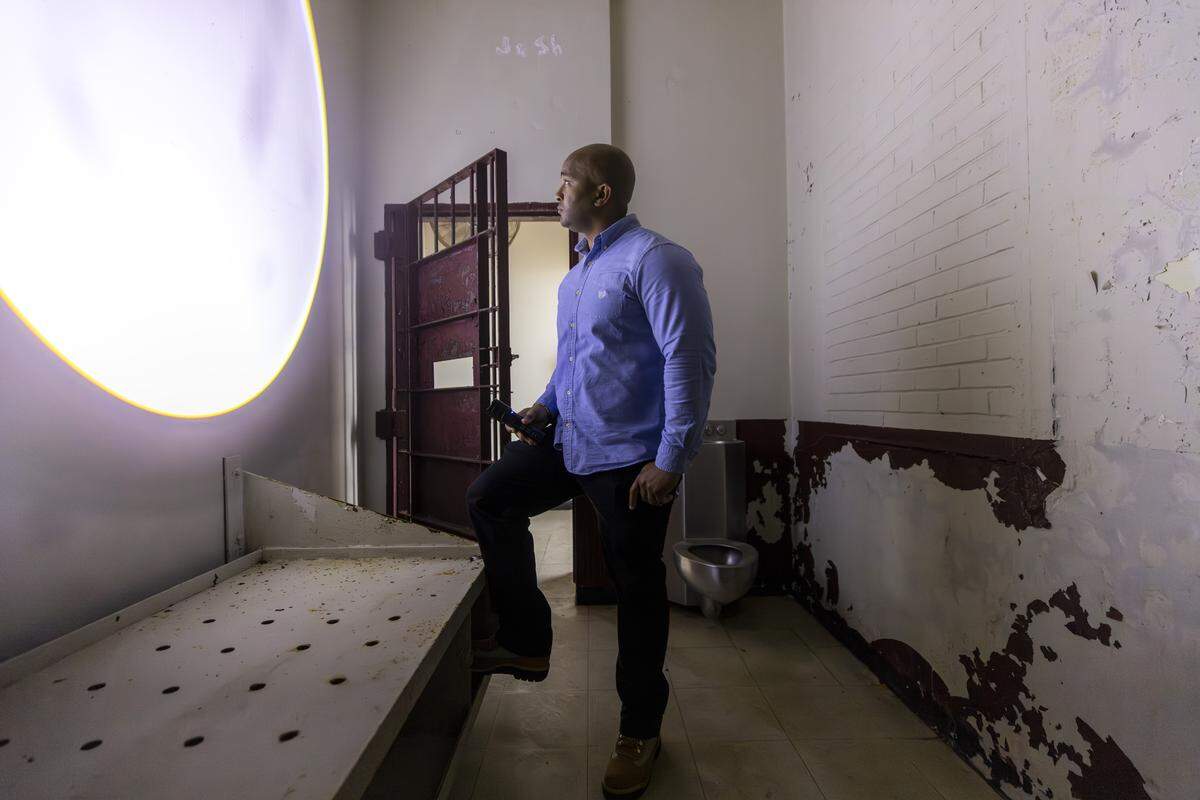 Kerwin Pittman stands with a flashlight inside a former solitary confinement room at the Wayne County Correctional Center in Goldsboro. 