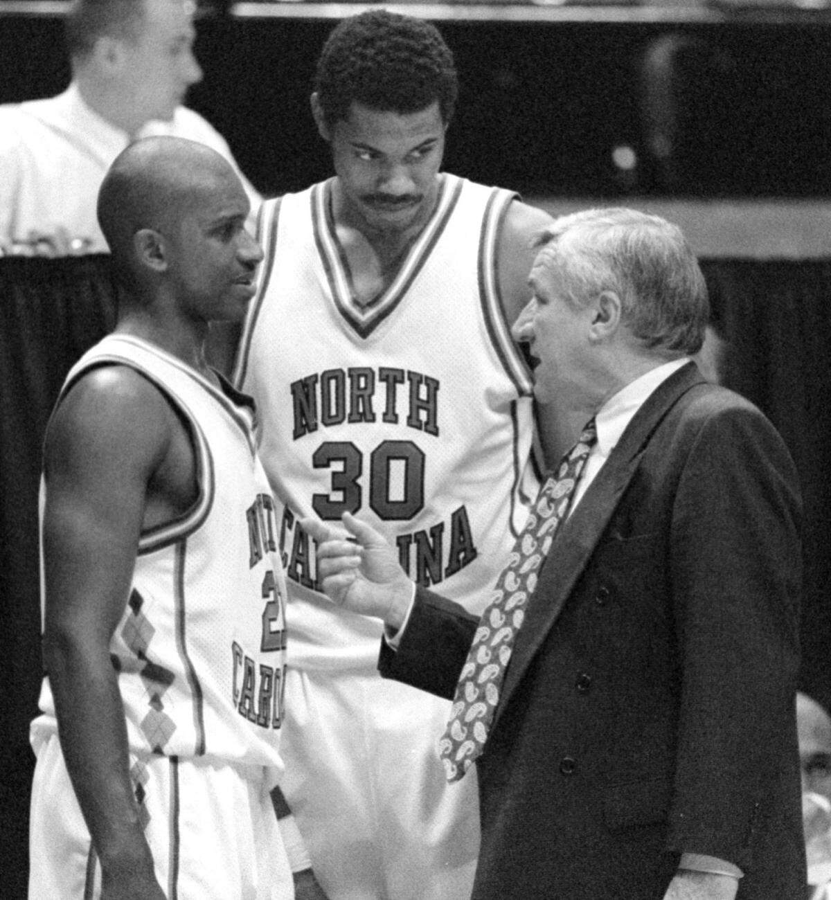 UNC coach Dean Smith, right, talks with players Donald Williams, left, and Rasheed Wallace during an NCAA tournament game against Iowa State in 1995.