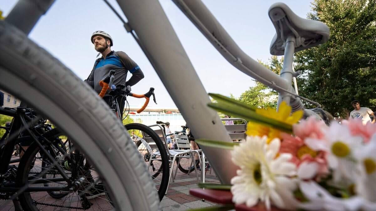 Alex Phillips stands with his bike before the annual Durham Ride of Silence honoring those killed or injured while biking at the CCB Plaza downtown on Wednesday, May 18, 2022.