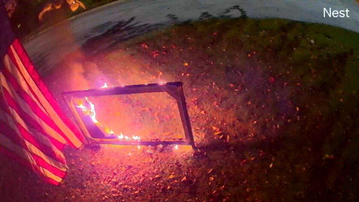 Security camera footage showing the ‘Trump Won’ yard sign owned by John Kane burning after a cyclist is seen lighting it on fire.