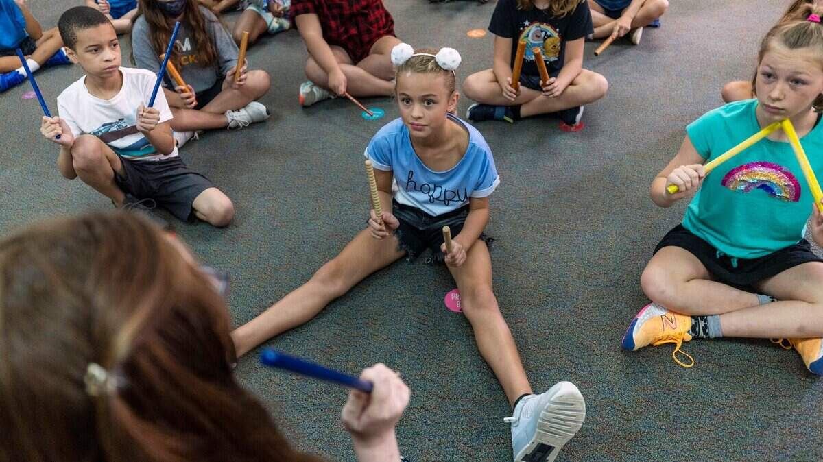 Lena Biron, a fifth grader at Sycamore Creek Elementary School, listens intently to music teacher Liz Yardley during class on Tuesday, August 16, 2022 in Raleigh, N.C. Yardley was teaching the fifth graders how to read music and count beats using rhythm sticks.