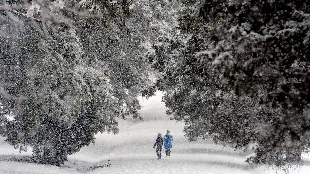 Two pedestrians walk down an access road near Hillandale Golf Course Thursday Feb. 13, 2014 in Durham, NC. Parts of the Triangle, including Durham, could see some frozen precipitation this weekend with a system moving through the state.