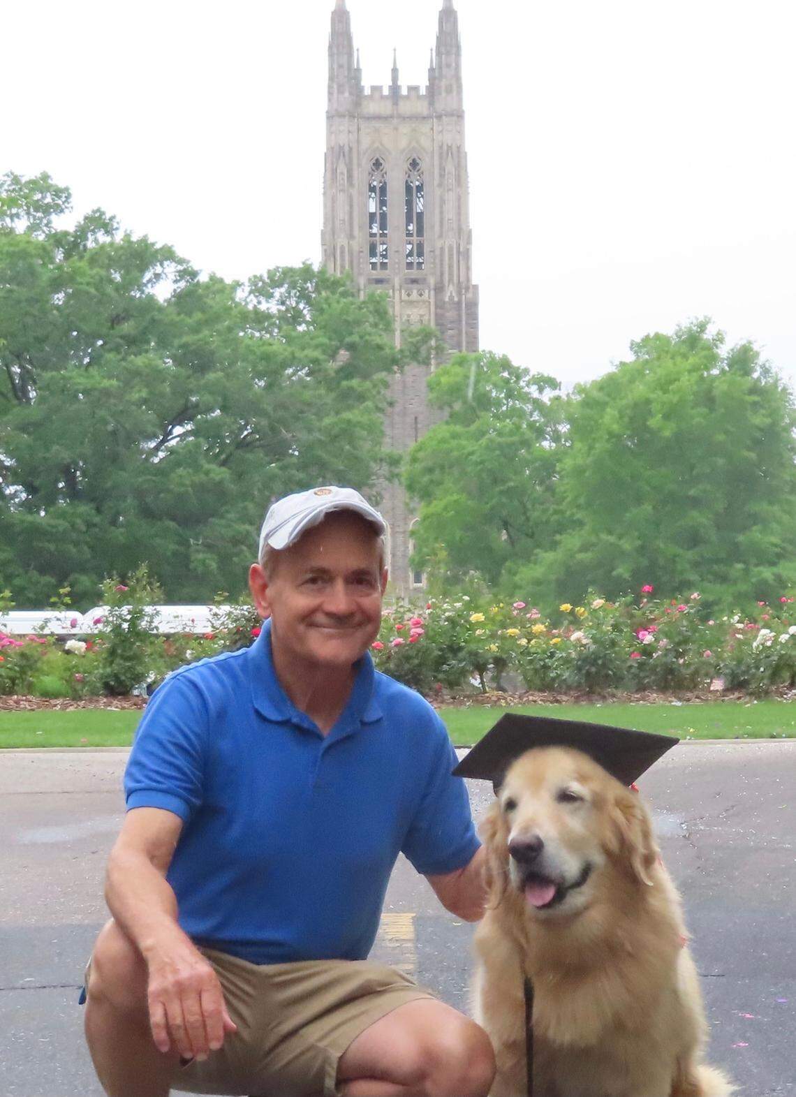 Golden retriever, Nugget, and her owner Keith Upchurch pose outside the Duke University Chapel before graduation day in May 2022.