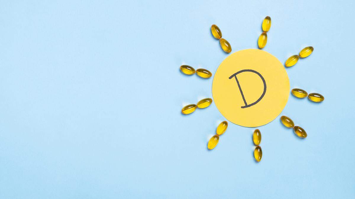 Yellow capsules in form of the sun and letter D on yellow paper. 