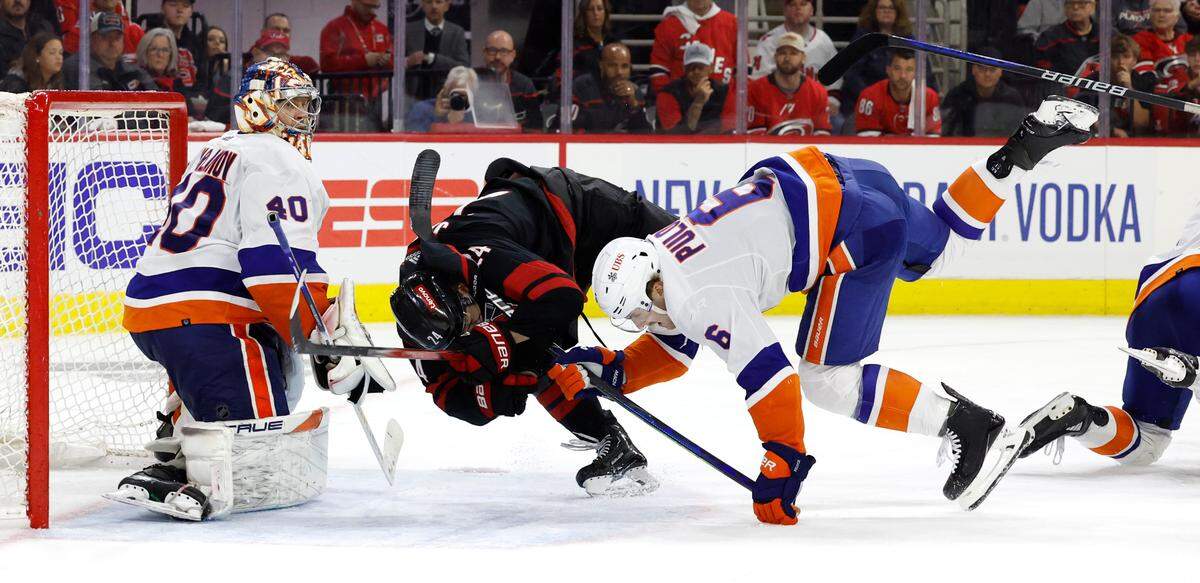 Carolina center Seth Jarvis (24) tangles with New York defenseman Ryan Pulock (6) in front of the goal during the third period of the Hurricanes’ 5-3 victory over the Islanders in the first round of the Stanley Cup playoffs at PNC Arena in Raleigh, N.C., Monday, April 22, 2024.