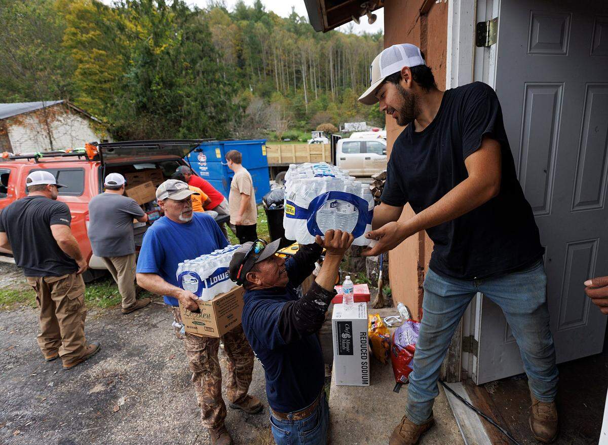 Volunteers unload donated supplies at Spear Country Store & Hardware as residents recover from the effects of Hurricane Helene on Tuesday, Oct. 1, 2024, in Newland, N.C.