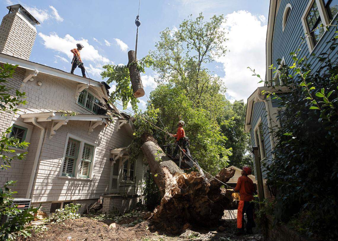 Crews work to remove a tree that fell on a house on Wednesday, Aug. 16, 2023, following Tuesday evening’s strong storms in Durham, N.C.