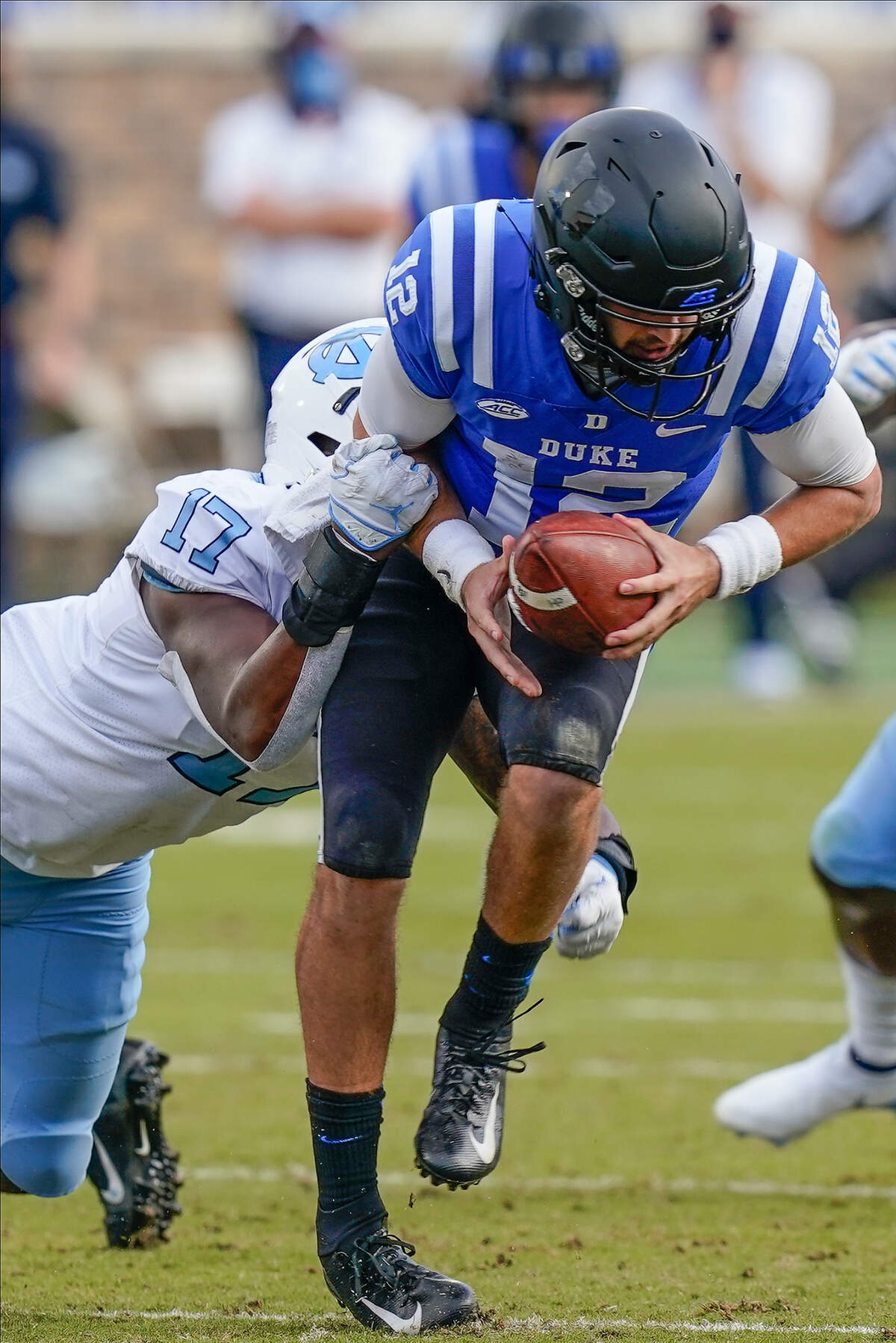 Duke Blue Devils quarterback Gunnar Holmberg (12) is sacked by North Carolina Tar Heels linebacker Chris Collins (17) during the second half at Wallace Wade Stadium. 