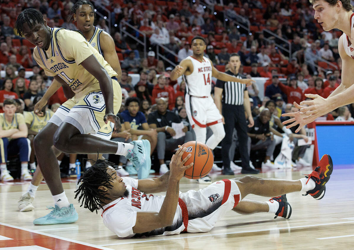 N.C. State’s Jayden Taylor looks to pass from the floor during the first half of the Wolfpack’s 82-76 win over Georgia Tech on Saturday, Feb. 3, 2024, at PNC Arena in Raleigh, N.C.
