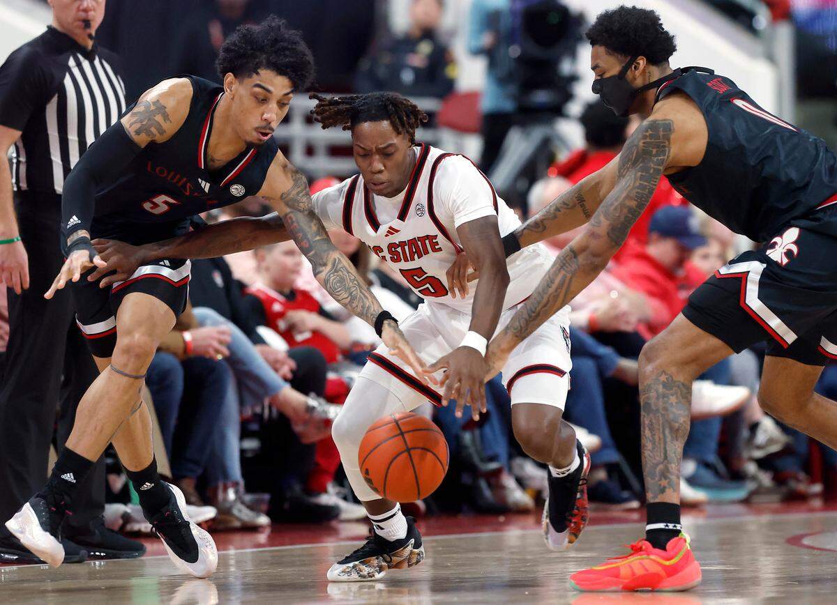 N.C. State’s Trey Parker pressures Louisville’s Terrence Edwards Jr. and James Scott during the second half of the Wolfpack’s 91-66 loss on Wednesday, Feb. 12, 2025, at Lenovo Center in Raleigh, N.C.