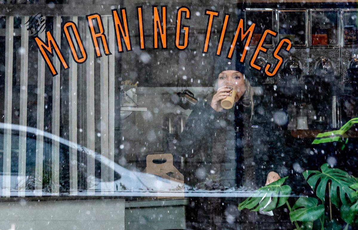 Melissa Hill enjoys her drink at The Morning Times as she watches snow fall in downtown Raleigh early Wednesday afternoon, Feb. 19, 2025.