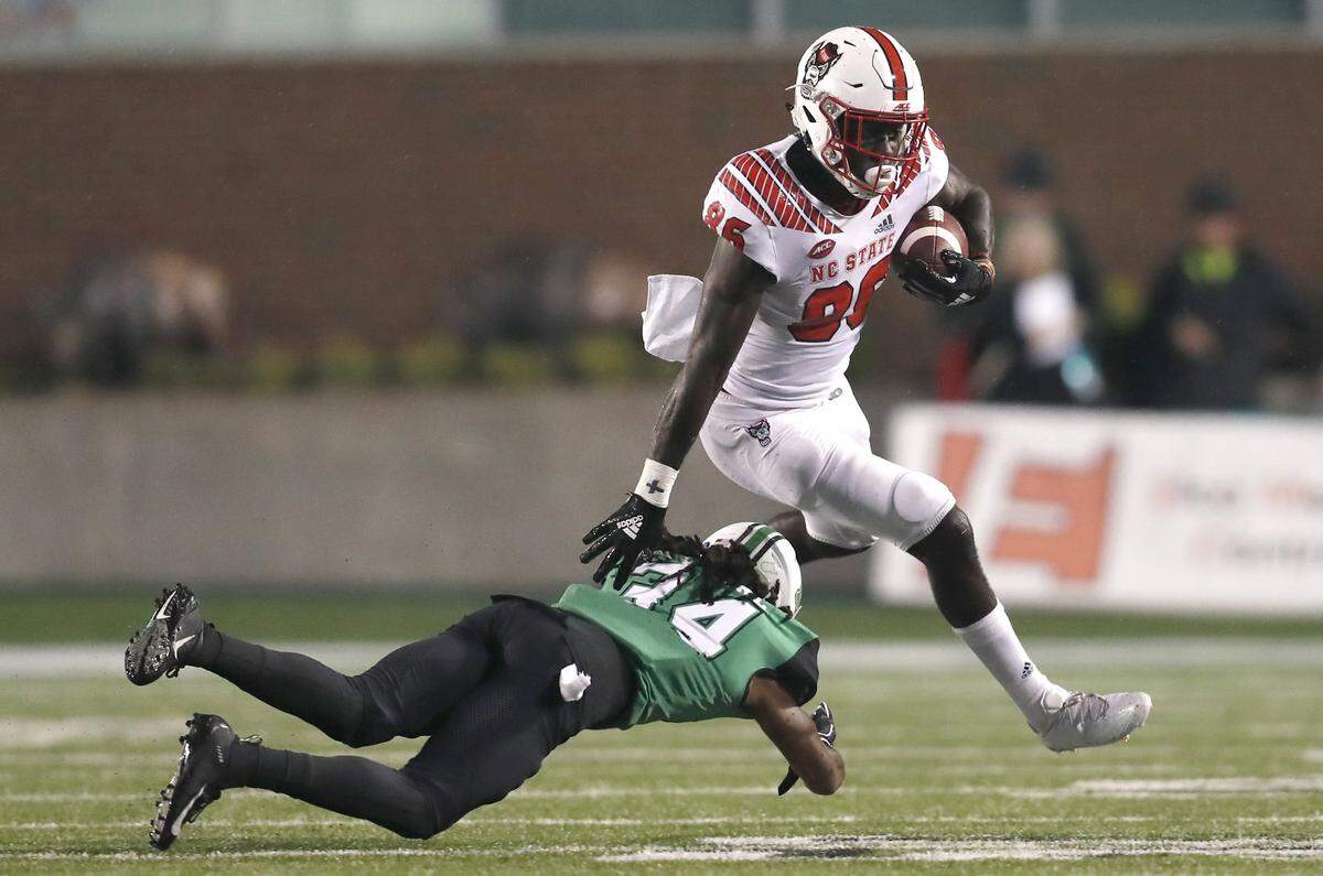 N.C. State wide receiver Emeka Emezie (86) avoids the tackle by Marshall linebacker Tavante Beckett (24) during the second half of N.C. State’s 37-20 victory over Marshall at Joan C. Edwards Stadium at Marshall University in Huntington, West Virginia Saturday, Sept. 22, 2018.