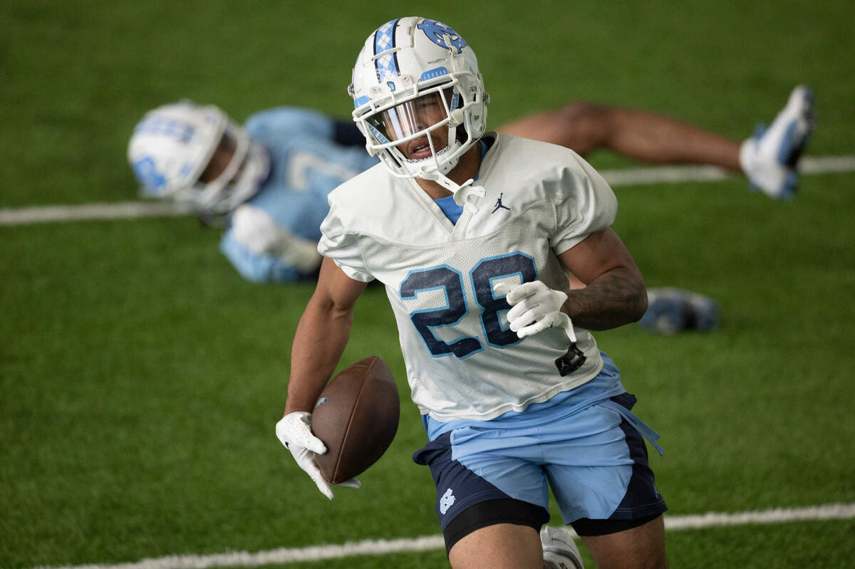North Carolina defensive back Alijah Huzzie (28) returns an interception after wide receiver Christian Hamilton (7) bobbled a pass reception during the opening day of spring football practice on Tuesday, March 19, 2024 in Chapel Hill, N.C.
