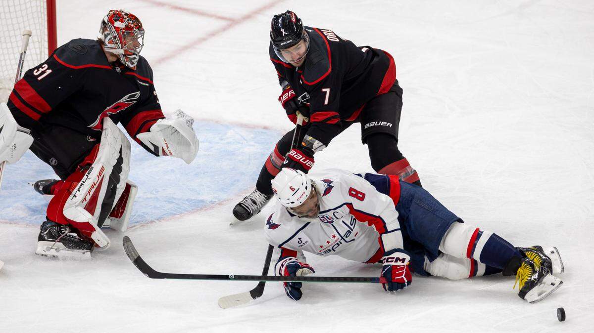 Washington Capitols left wing Alex Ovechkin (8) is checked to the ice by Carolina Hurricanes defenseman Dmitry Orlov (7) in front of Hurricanes goalie Frederik Andersen (31) in the second period during Game 3 of their series on Saturday, May 10, 2025 at Lenovo Center in Raleigh, N.C.