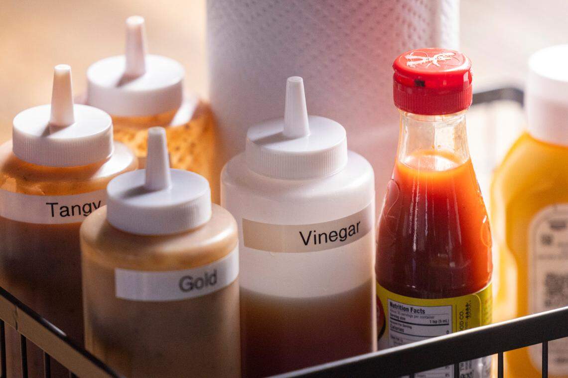 An assortment of condiments and sauces sits in a basket during the opening of Longleaf Swine in Raleigh Friday, Nov. 4, 2022.