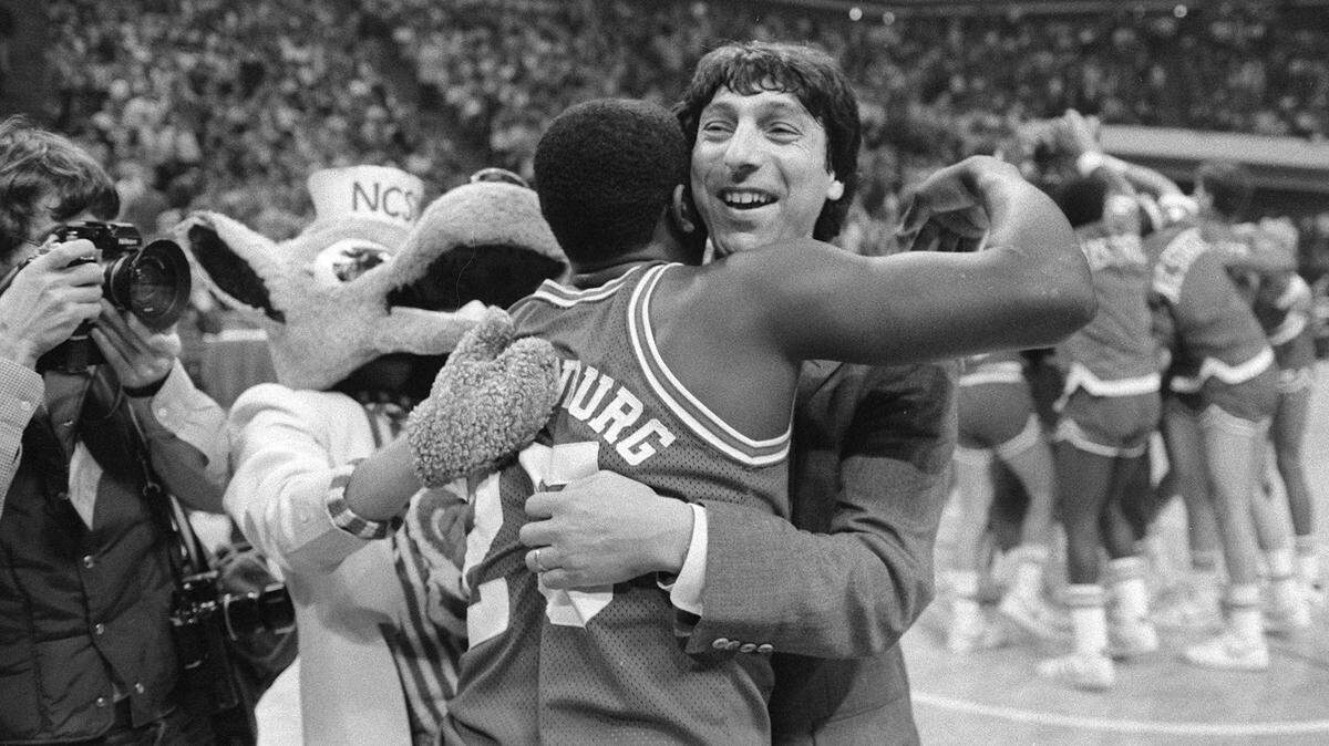 N.C. State coach Jim Valvano hugs Dereck Whittenburg after the Pack defeated the Tar Heels 91-84 in Atlanta in March 1983.