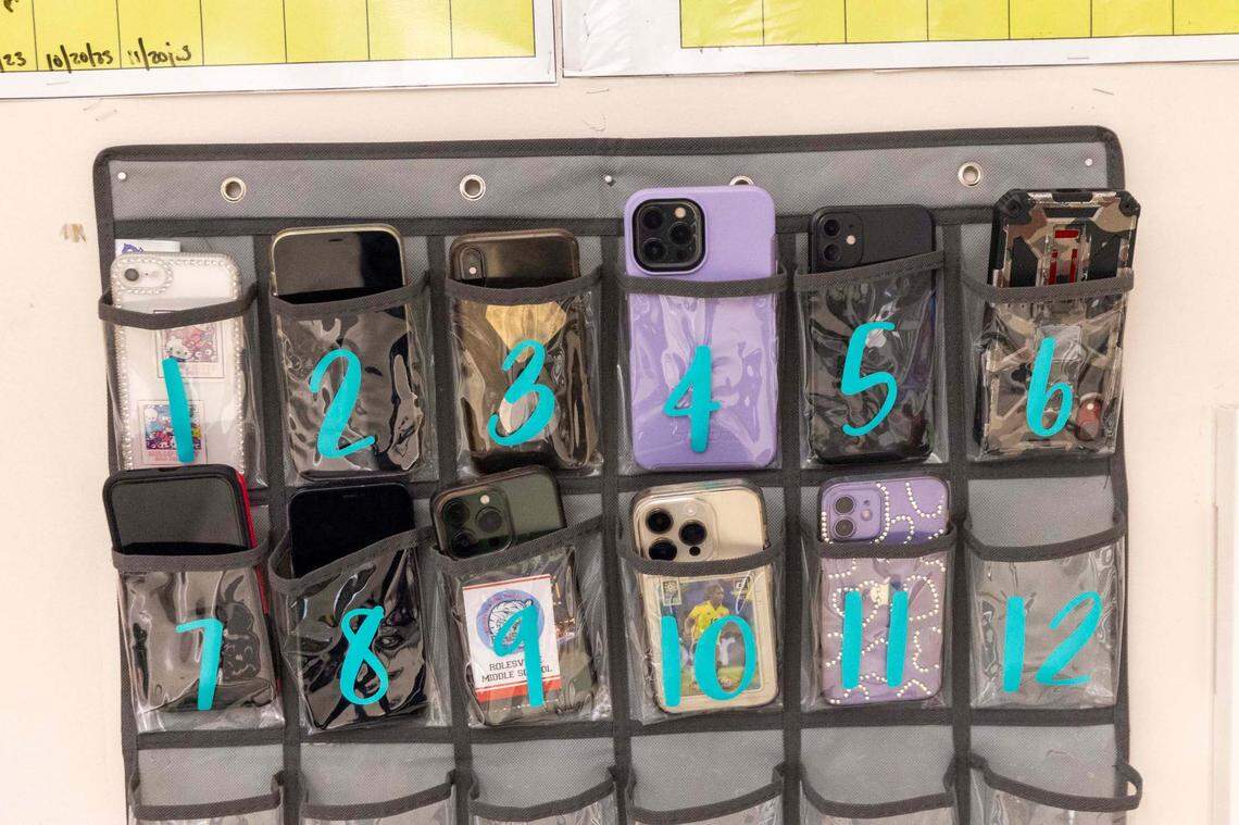 Phones sit in a caddy in Kyanna McCall’s seventh-grade classroom at Rolesville Middle School on Wednesday, March 27, 2024. Wake County school board gave final approval on June 3, 2025 to a districtwide policy regulating cellphone use in schools.