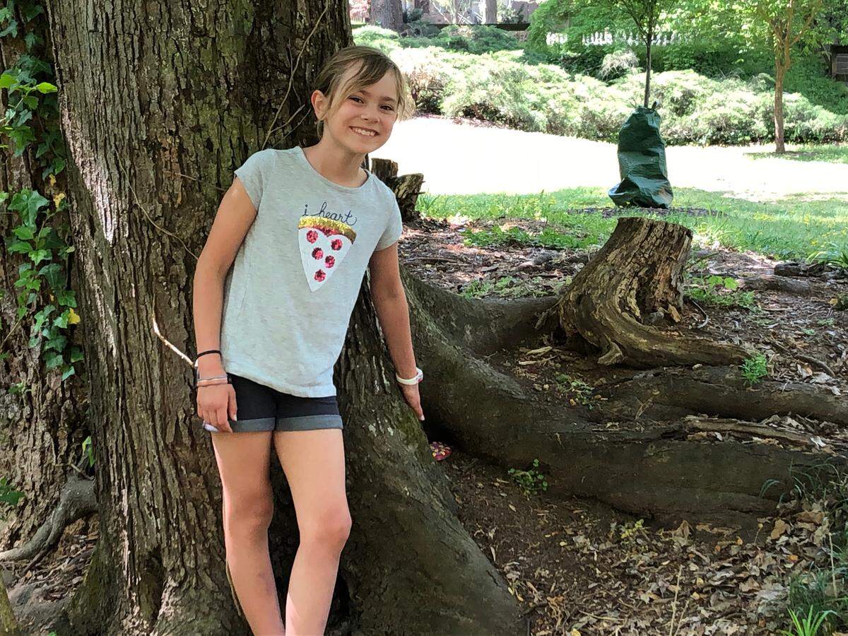 Kennedy Becker, 8, points out a rock she painted to look like an Easter egg and then hid for families to search for in Fallon Park in Raleigh to celebrate Easter during the coronavirus pandemic.
