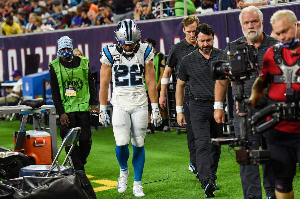 Panthers running back Christian McCaffrey, center, hangs his head as he leaves the medical tent after a hamstring injury during the game against the Texans at NRG Stadium on Thursday, September 23, 2021 in Houston, TX.